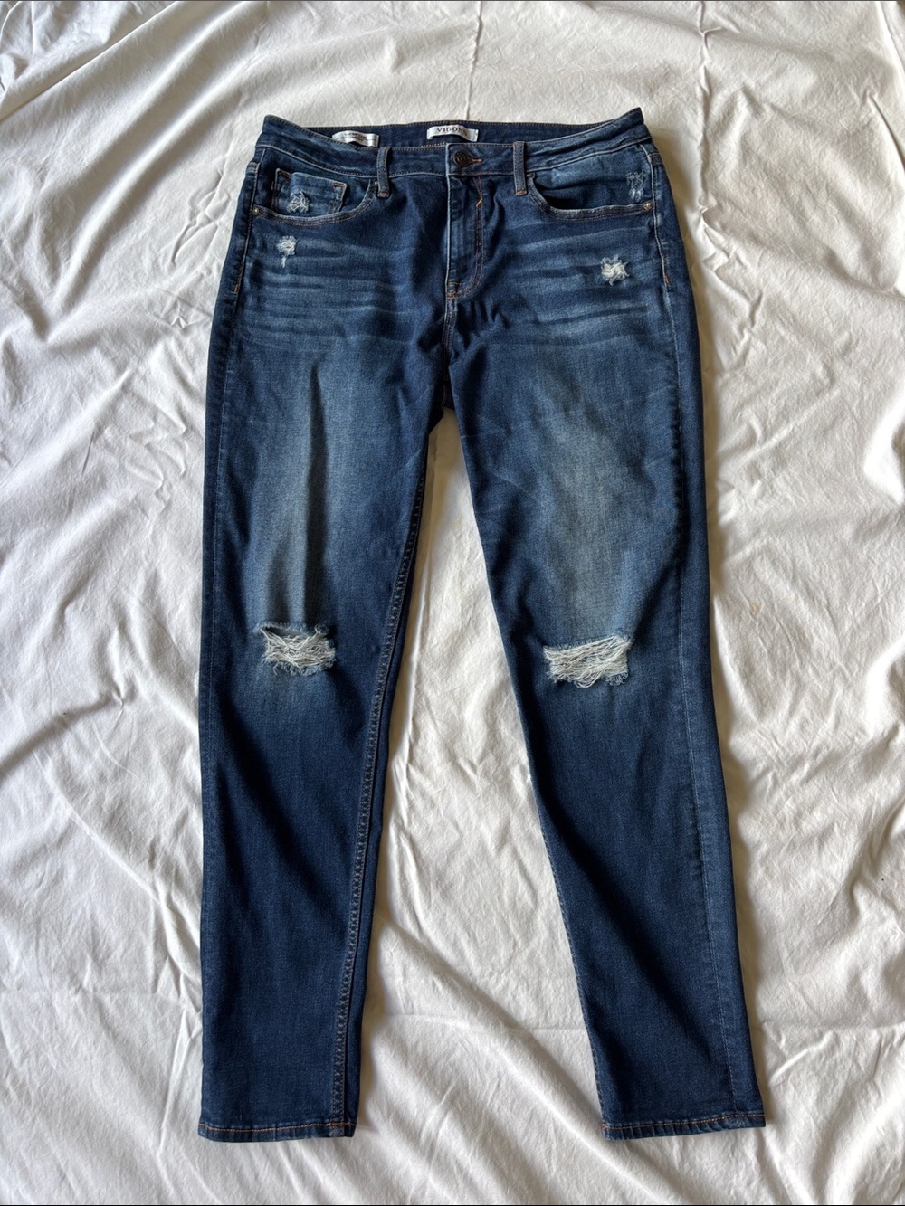 Women’s Vigoss jeans, size 31, in a medium-dark wash with knee distressing.